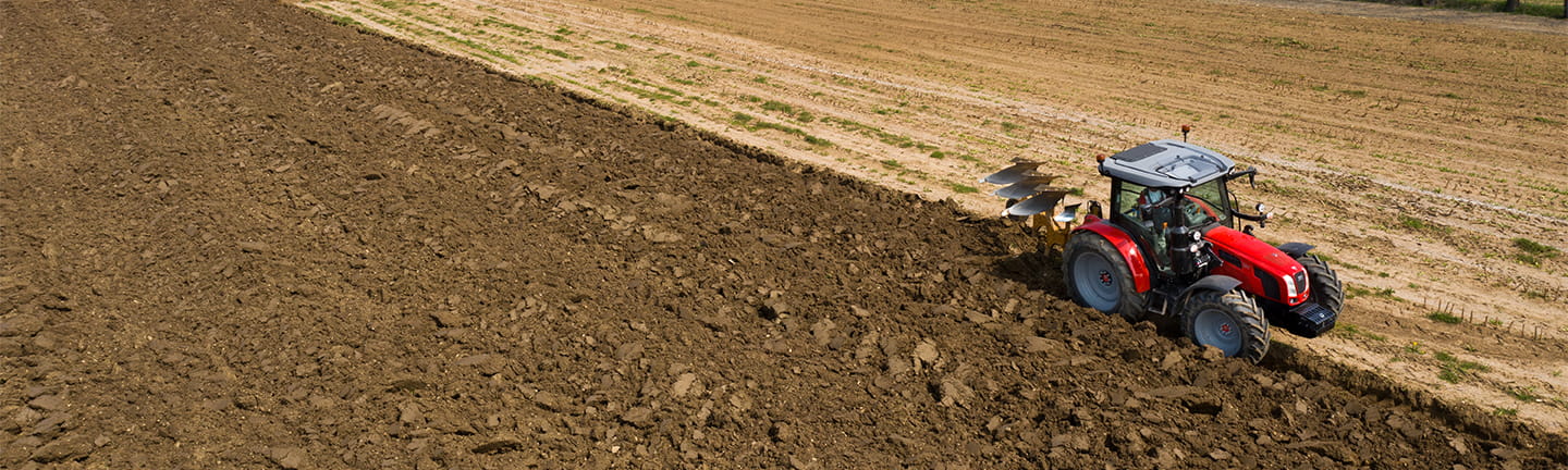 un trattore ara ampi campi di terra